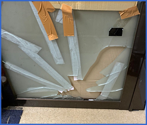 ヒビが入ったガラスにガムテを貼っている画像