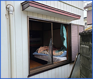 すべてガラスが割れてしまった白い壁の家画像