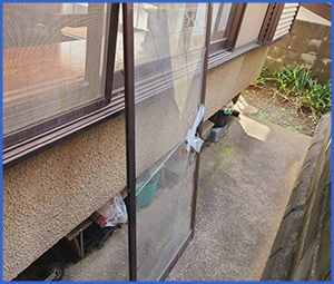 割れたガラス窓が外され地面に置かれている画像