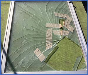 ガムテープが貼られた割れたガラス画像