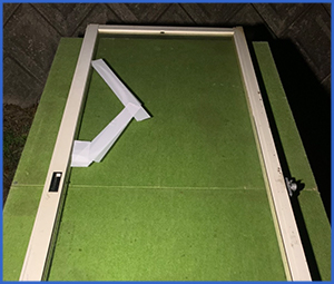 白いテープで補強した割れたガラス窓画像