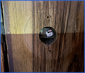 ドアノブが外れて穴が開いた木製ドア画像