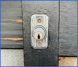 黒く塗った木製の扉サッシの鍵画像