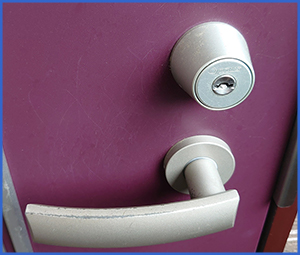 赤紫色の玄関扉の銀のドアノブと鍵穴画像