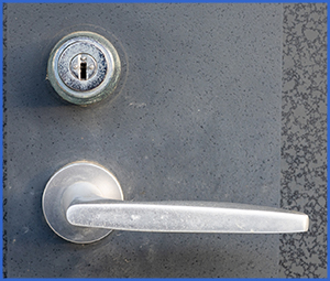 濃い灰色のドアの銀の鍵穴とドアノブの画像